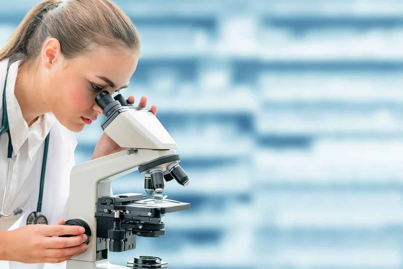 woman looking into a microscope