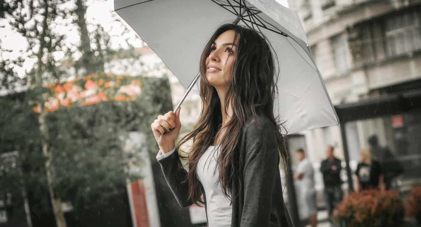 woman standing in the rain with an umbrella