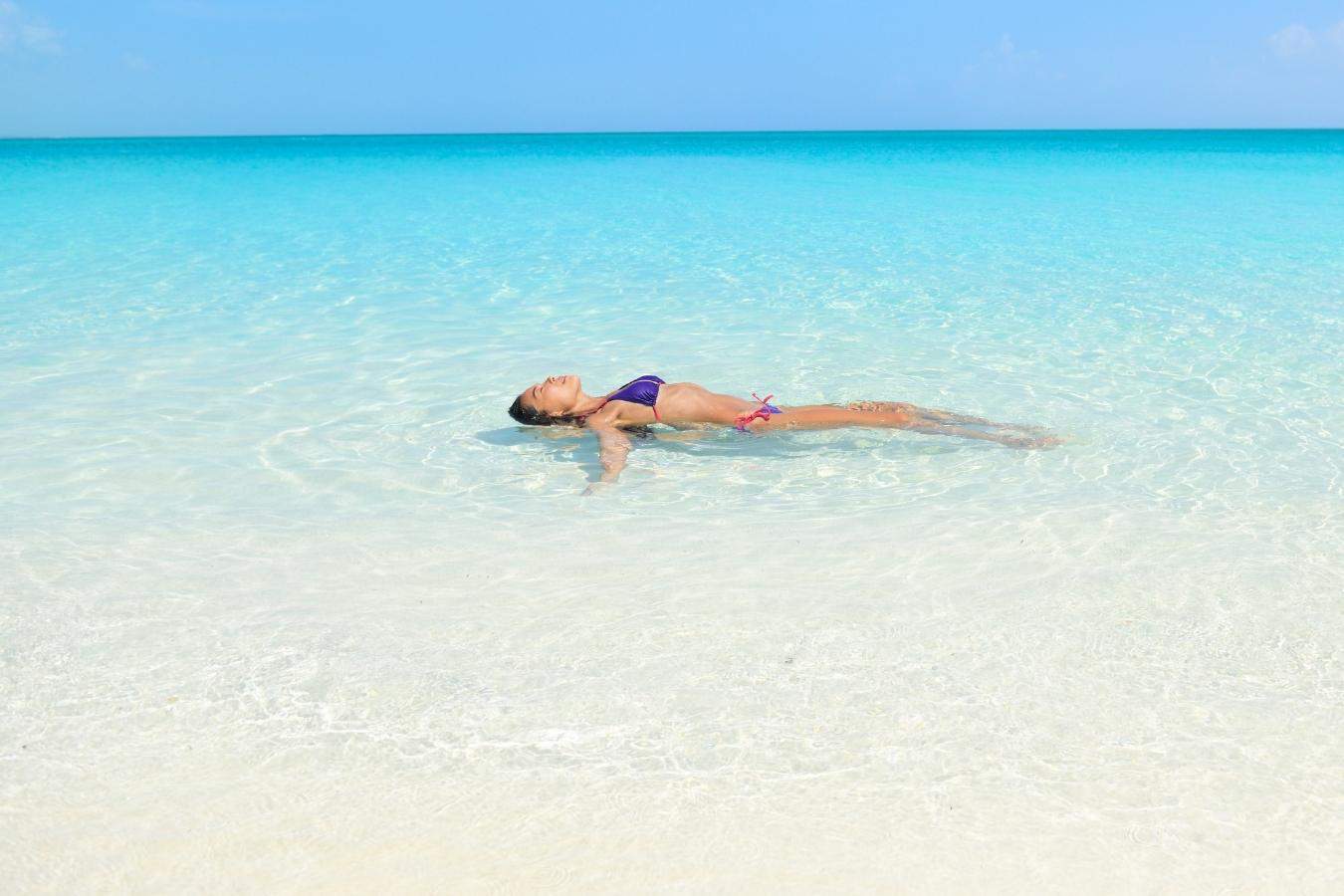 woman lying in the water near a beach