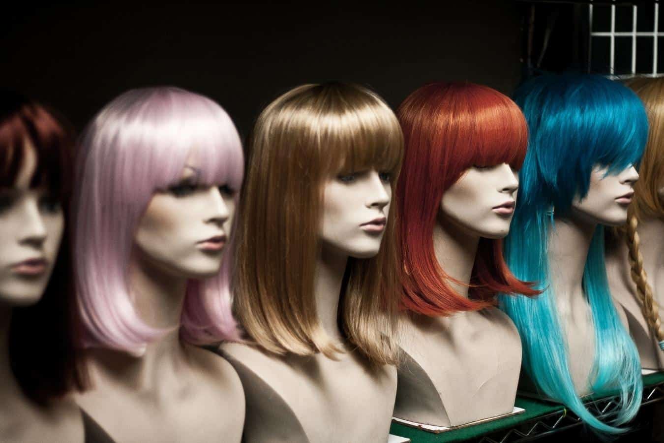 mannequins on a row with wigs on them